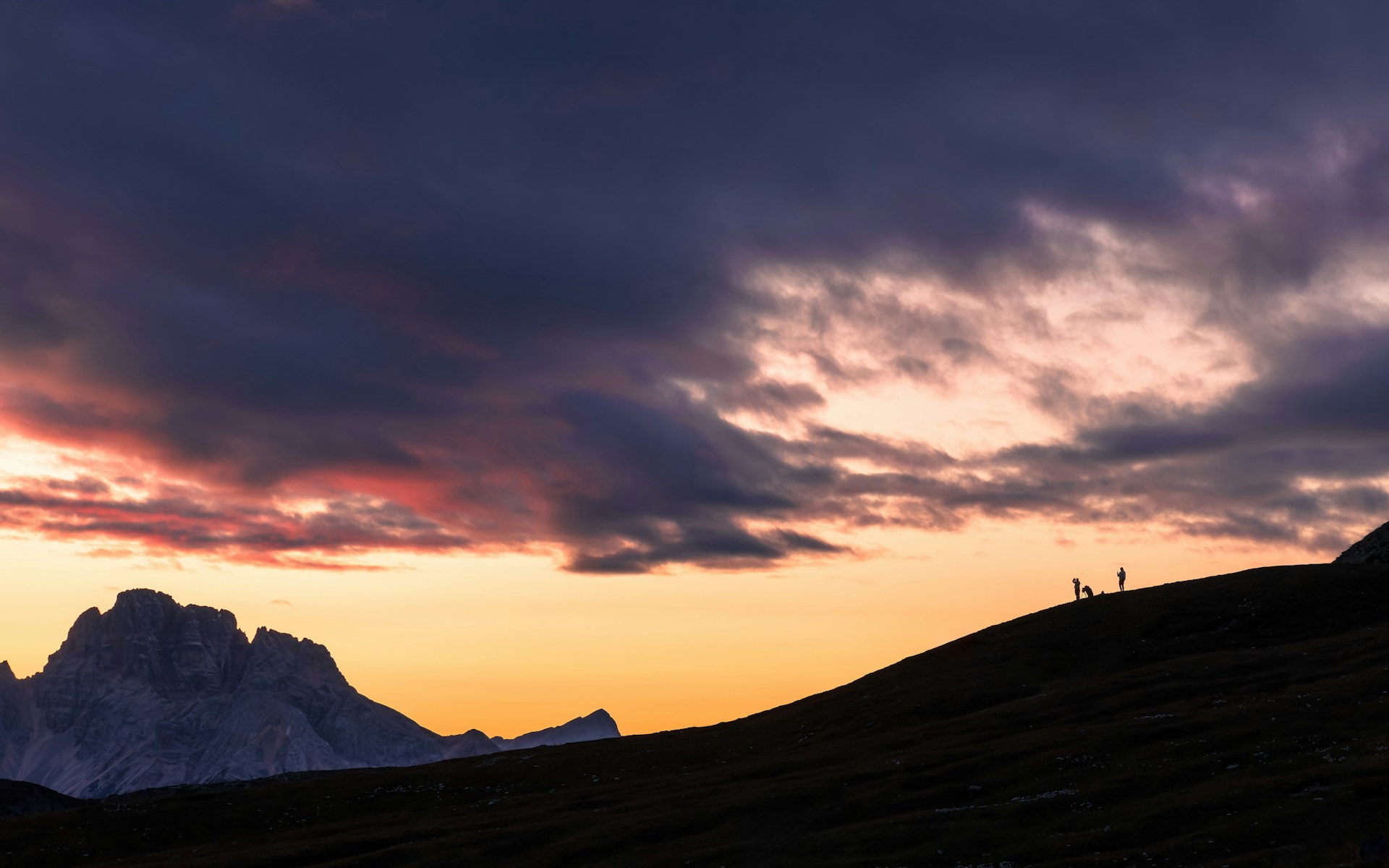 Stylised illustration: hiker silhouette on a sunset mountain ridge with a glowing smartphone